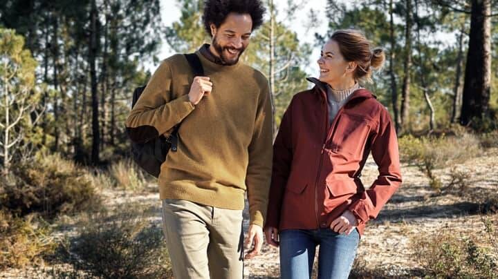 divi cilvēki pastaigājas mežā