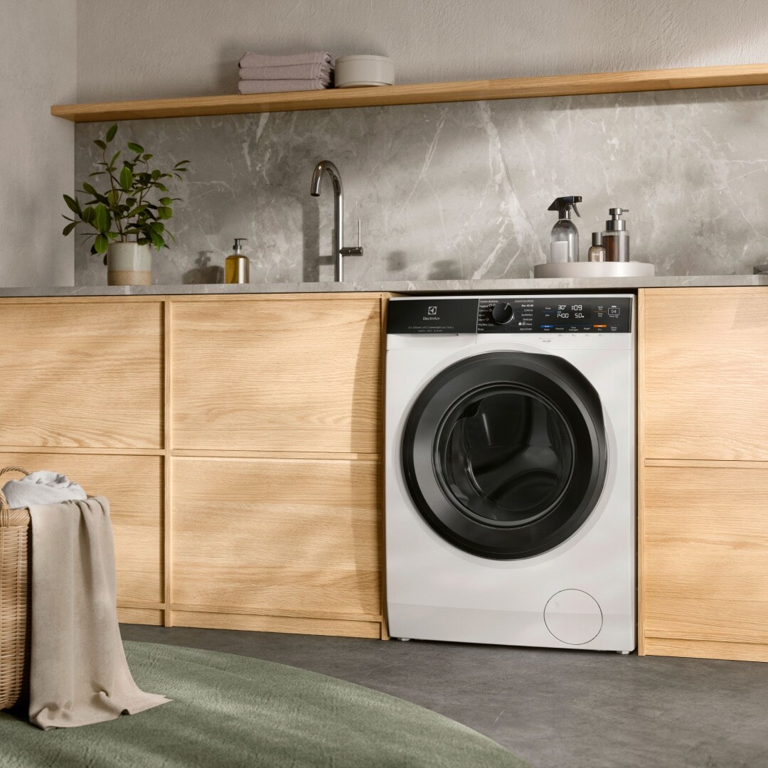 Electrolux veļas mašīna ar žāvētāju zem letes.