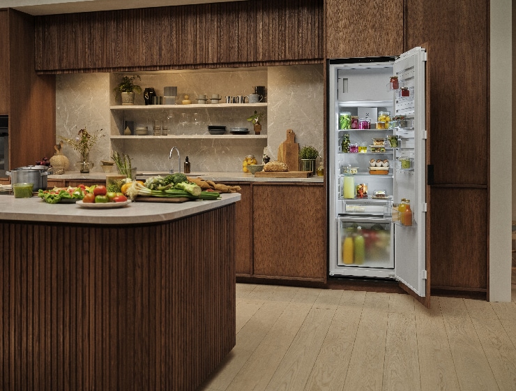 Virtuves skats ar atvērtu ledusskapi fonā.